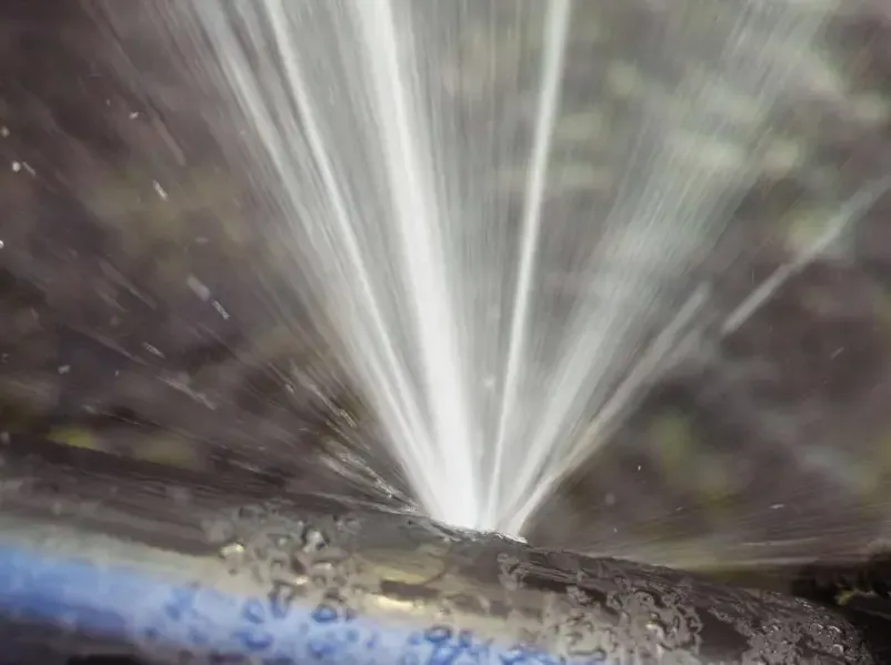 Water spraying out of a split pipe under full line pressure